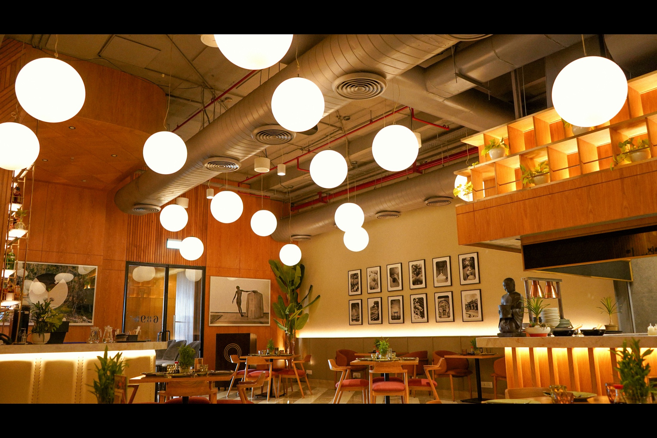 The dining room of an Indian restaurant with hanging globe lights