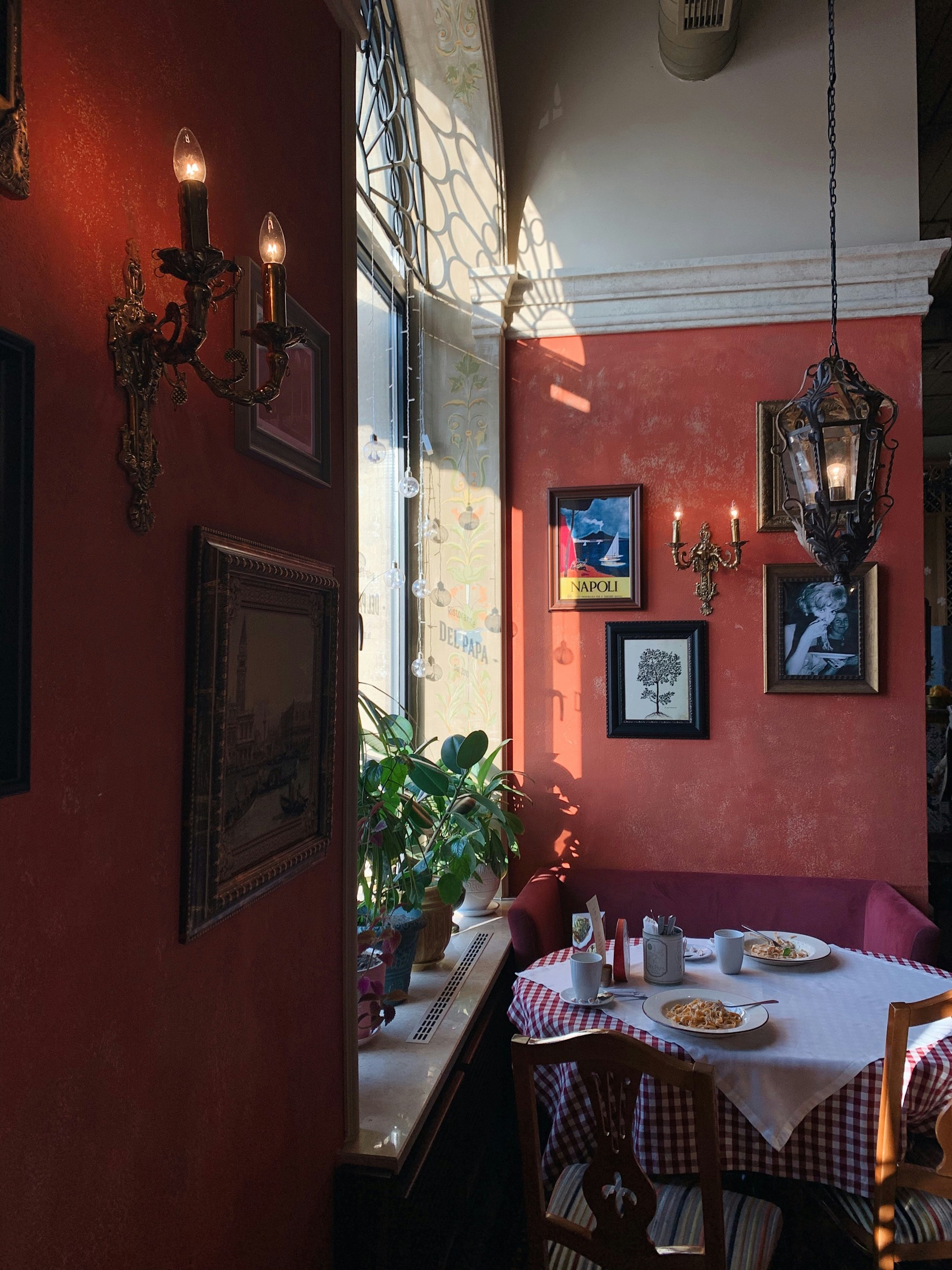 A warm Italian trattoria interior with a plate of pasta on a checkered tablecloth